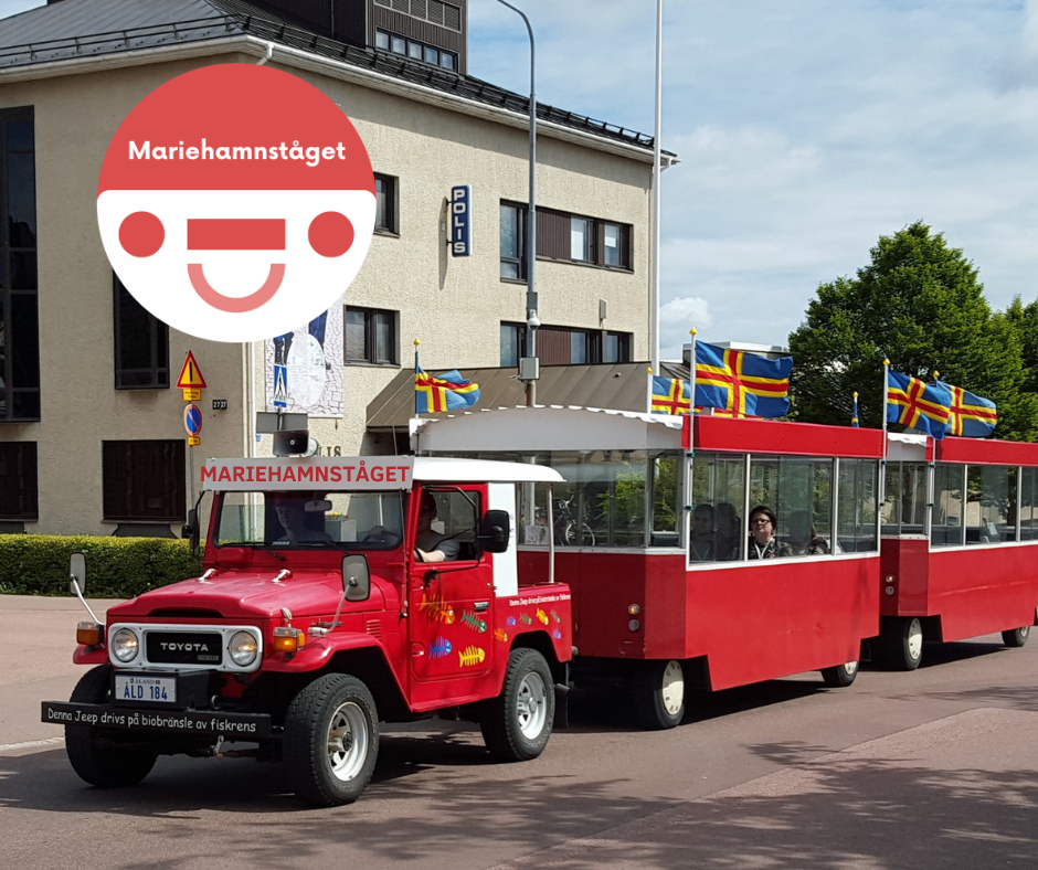 Mariehamnståget: ett rött tåg på hjul med en Toyota som drar. 